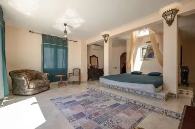 a bedroom with a king sized bed and a chair at Maroccana in Dobra Voda
