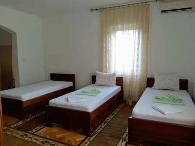 two beds in a room with a window at Apartments Old Olive in Bar