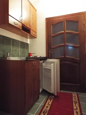 a kitchen with wooden cabinets and a sink and a refrigerator at Apartments Old Olive in Bar