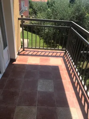 a balcony with a black railing and a tile floor at Vila Laguna in Sutomore
