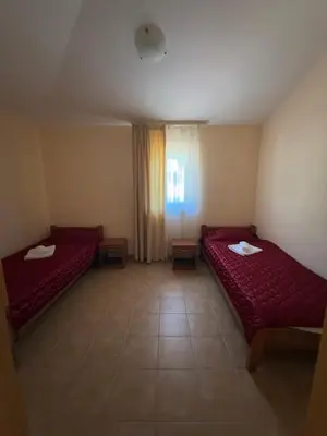 a room with two red beds and a window at Vila Laguna in Sutomore