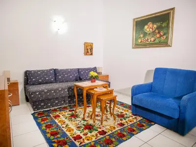 a living room with a blue couch and a table at Apartments Adria in Petrovac na Moru