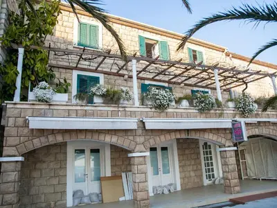 a brick building with windows and plants on it at Apartments Adria in Petrovac na Moru