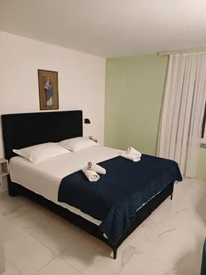 a bedroom with a bed with two towels on it at Apartments Adria in Petrovac na Moru