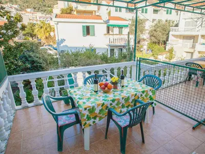 a table and chairs on a balcony with a table and fruit at Apartments Adria in Petrovac na Moru