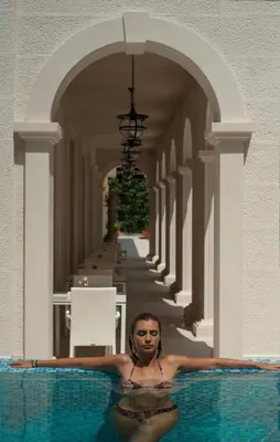 a woman is sitting in a swimming pool at Hotel Moskva in Budva