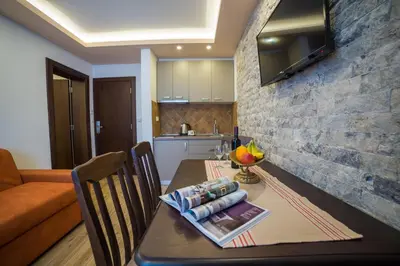 a kitchen and dining room table with a dining room gmaxwell gmaxwell gmaxwell gmaxwell at Guest House S-Lux in Petrovac na Moru