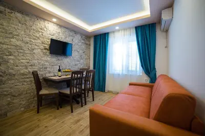 a living room with a couch and a dining room at Guest House S-Lux in Petrovac na Moru