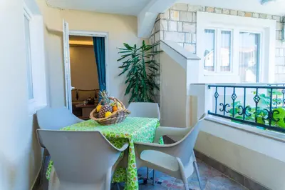a balcony with a table and chairs and a window at Guest House S-Lux in Petrovac na Moru
