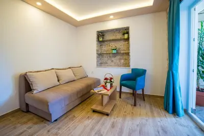 a living room with a couch and a blue chair at Guest House S-Lux in Petrovac na Moru