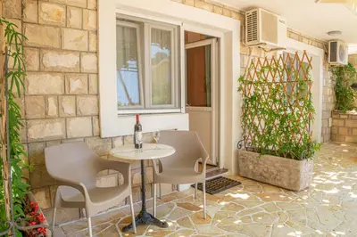 a patio with a table and chairs next to a building at Guest House S-Lux in Petrovac na Moru