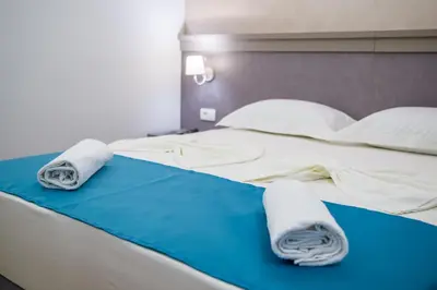 a bed with towels and pillows on top of it at Guest House S-Lux in Petrovac na Moru
