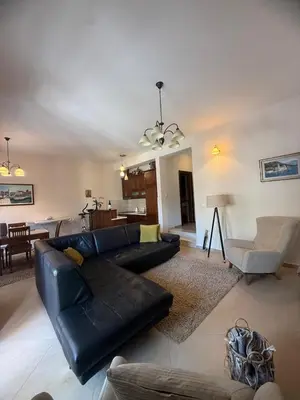 a living room with a black leather couch and a table at Apartment Benvenuti in Kotor