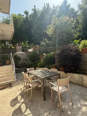 a table and chairs in a backyard with a table and chairs at Apartment Benvenuti in Kotor