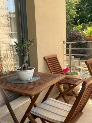 a wooden table and chairs with a potted plant on a porch at Apartment Benvenuti in Kotor