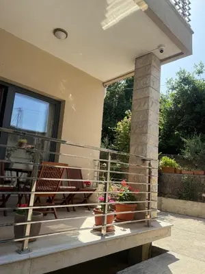 a balcony of a house with two chairs and flowers at Apartment Benvenuti in Kotor