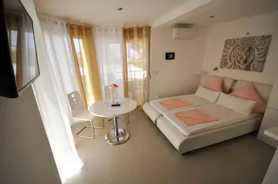 a small bedroom with a bed and a table at Villa Medusa Apartments - Adults only - in Dobra Voda