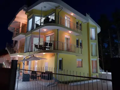 a yellow building with balconies and an umbrella at Villa Medusa Apartments - Adults only - in Dobra Voda