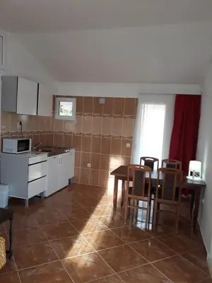 a kitchen with a table and chairs in a room at Apartments Jovanic with 2 bedrooms in Sutomore