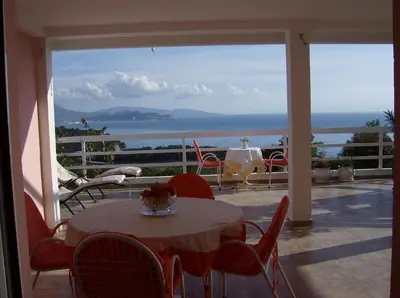 a patio with a table and chairs and a view of the ocean at Apartments Jovanic with 2 bedrooms in Sutomore