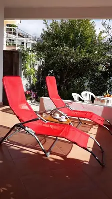 a pair of red chairs sitting on a patio at Apartments Jovanic with 2 bedrooms in Sutomore