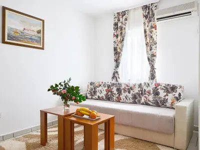 a living room with a couch and a table at Blue Mare Apartment in Petrovac na Moru