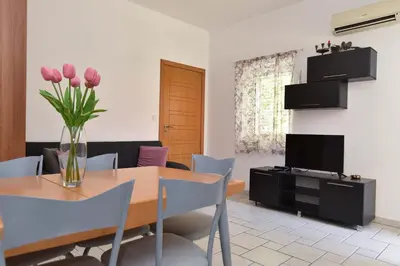 a dining room with a table and a vase of flowers at Blue Mare Apartment in Petrovac na Moru