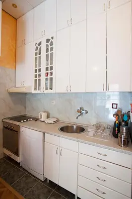 a kitchen with white cabinets and a sink at Apartment Mira in Budva