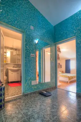 a room with a blue wall with a mirror at Apartment Mira in Budva