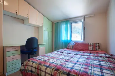 a bedroom with a bed and a desk and a window at Apartment Mira in Budva
