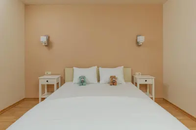 two teddy bears sitting on a bed with two tables at Kotor Luxury View in Kotor