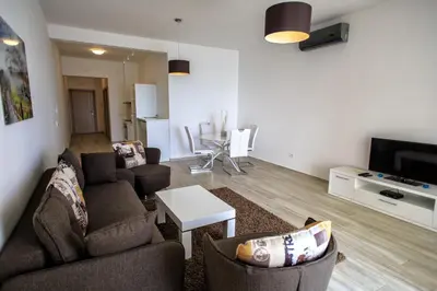 a living room with a couch and chairs and a tv at Nautilus Apartments in Dobra Voda