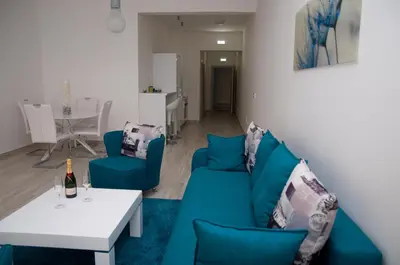 a living room with a blue couch and a table at Nautilus Apartments in Dobra Voda