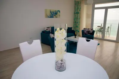 a white table with a vase with flowers on it at Nautilus Apartments in Dobra Voda