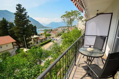 a balcony with a table and a chair and a view at Bay View Apartments in Kotor