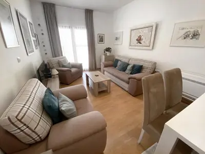 a living room with two couches and a table at Welcome Apartments in Petrovac na Moru