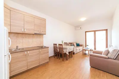a kitchen and living room with a couch and a table at Welcome Apartments in Petrovac na Moru