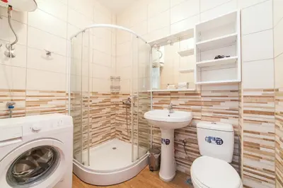 a bathroom with a toilet a sink and a washing machine at Welcome Apartments in Petrovac na Moru