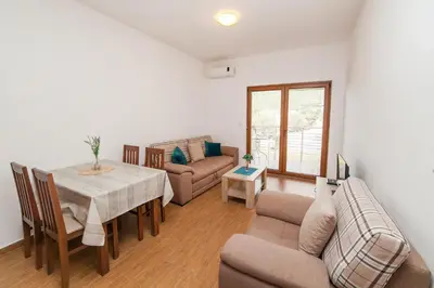 a living room with a table and a couch at Welcome Apartments in Petrovac na Moru