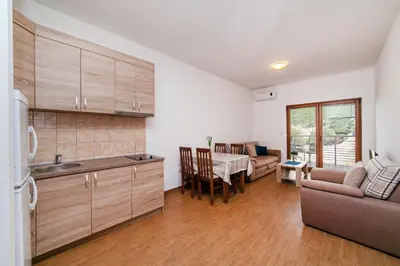 a kitchen and living room with a couch and a table at Welcome Apartments in Petrovac na Moru