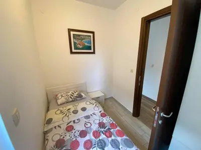 a small bedroom with a bed and a mirror at Apartment Dragan in Budva