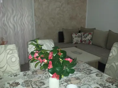 a living room with a table with a vase of flowers at Apartment Dragan in Budva