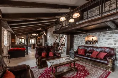 a living room with leather furniture and a loft at Talići Hill - Rustic Villas in Sutomore