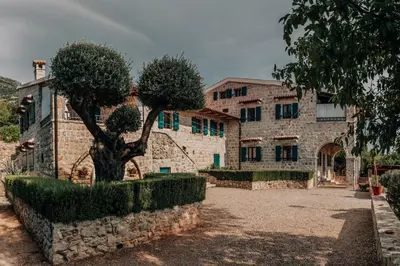 a stone building with a tree in front of it at Talići Hill - Rustic Villas in Sutomore