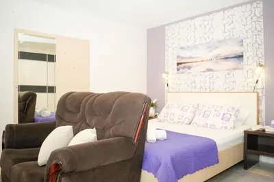 a bedroom with a couch and a chair and a bed at Apartments Bućin in Kotor
