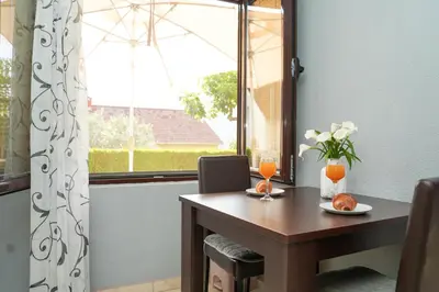 a dining room table with a window and a table with oranges at Apartments Bućin in Kotor