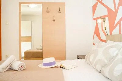 a bedroom with a bed with a hat and a mirror at Apartments Bućin in Kotor
