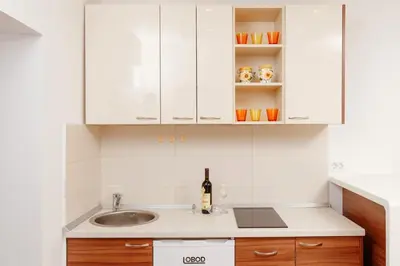 a kitchen with white cabinets and a sink at Apartments Blue Sea in Kotor