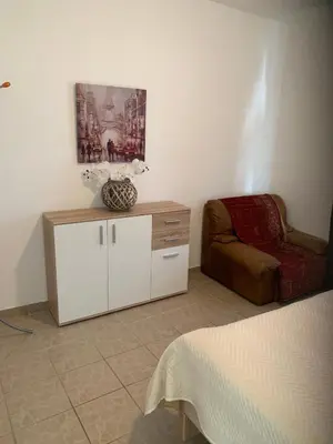 a room with a couch and a cabinet and a chair at Apartments Ljiljana in Bar