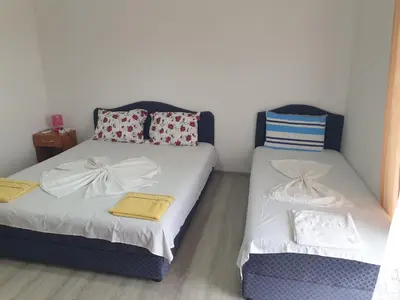 a bedroom with two beds and a chair at House Kraja in Ulcinj